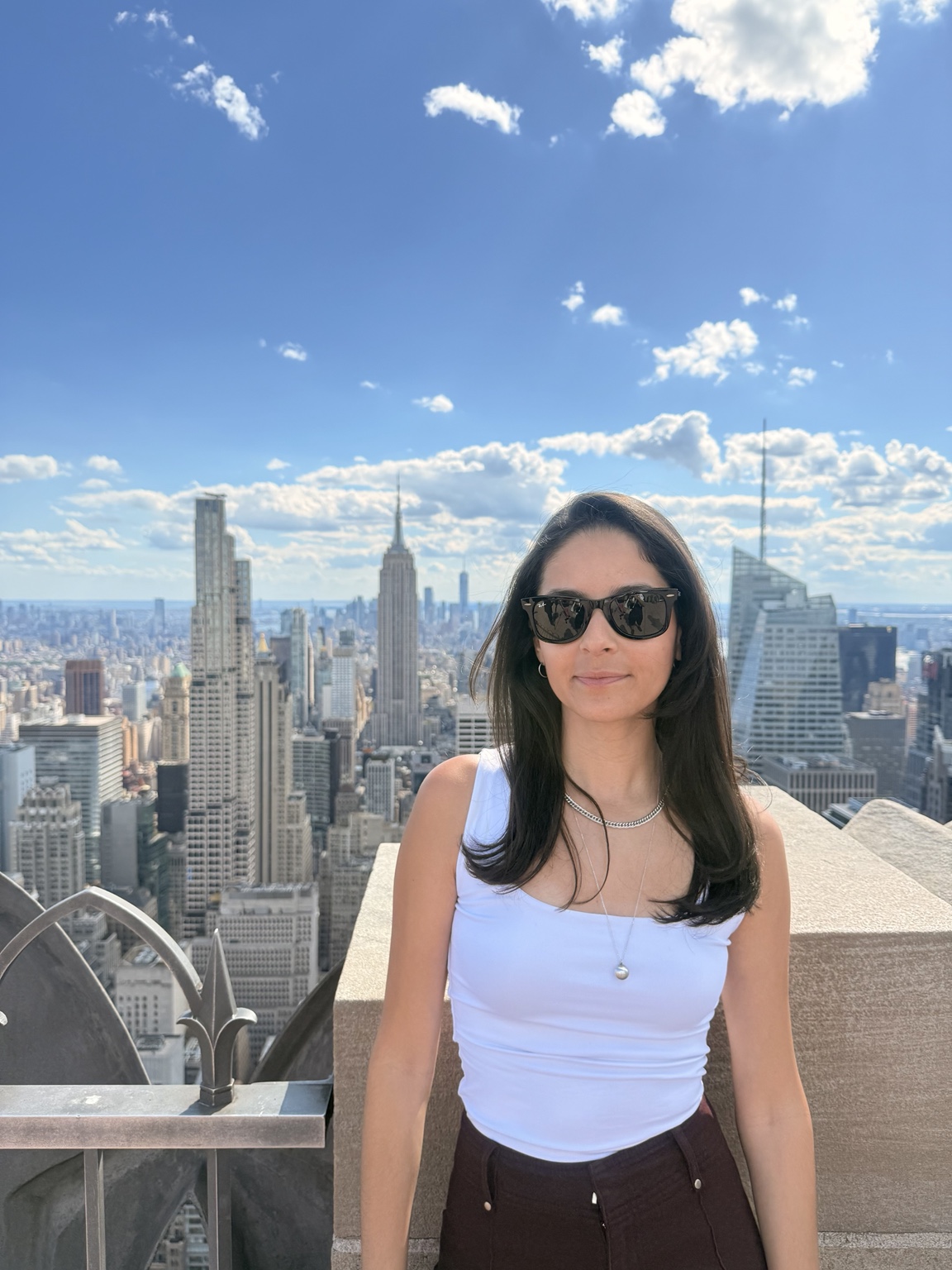 Evelyn no observatório Top of the Rock, em Nova York, com o skyline da cidade e o Empire State Building ao fundo.